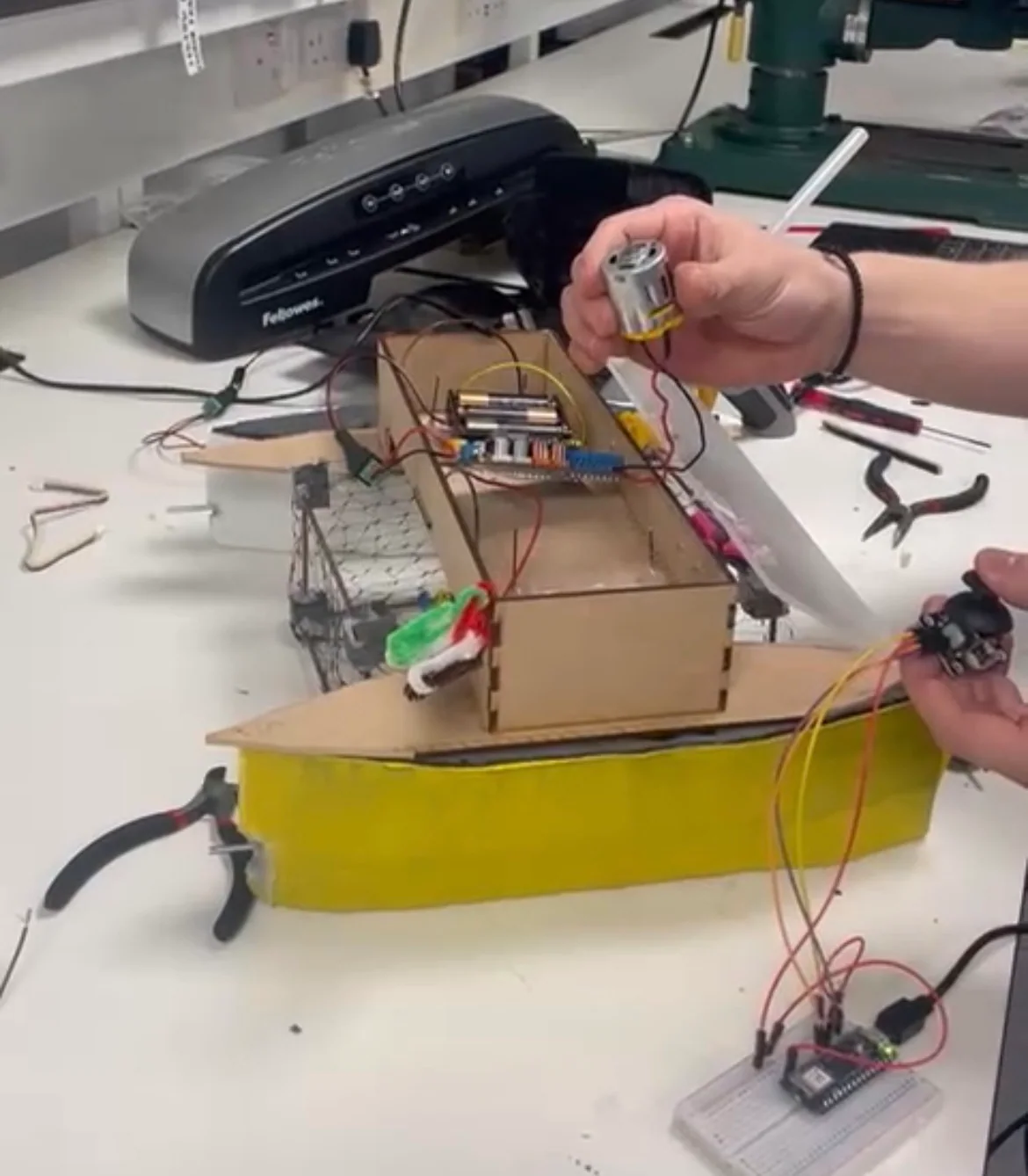 The assembled twin-hull boat on a workbench, with the MDF bridge, wiring and electronics visible.