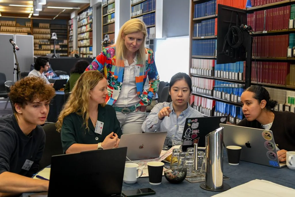 The VoiceWell team working together at laptops during the hackathon.